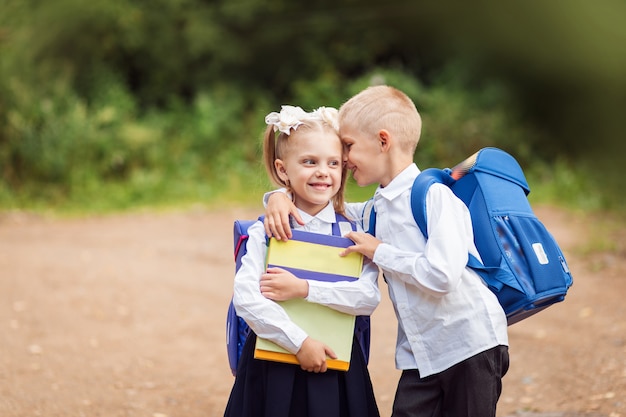 写真 小さな子供、1年生、学校の制服、バックパックと教科書、幸せな学生