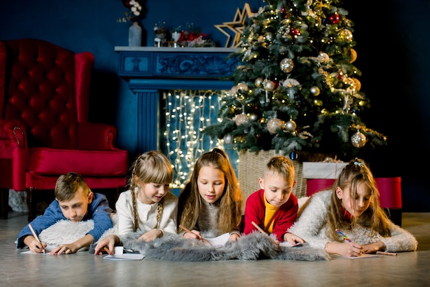 小さな子供たちはサンタに手紙を書いて、お互いにクリスマスの話をします