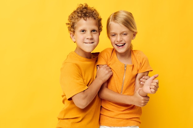 Small children in yellow tshirts standing side by side childhood emotions isolated background unaltered