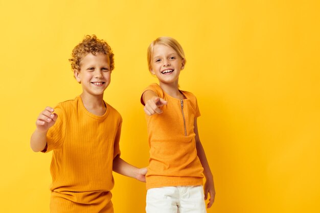 노란색 티셔츠를 입은 어린 아이들은 어린 시절의 감정 외진 배경을 바꾸지 않고 나란히 서 있습니다.