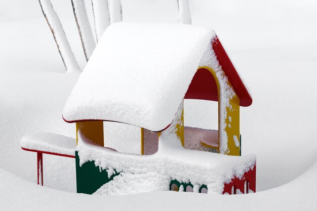 Small childrens redyellowgreen house in kindergarten for children in winter landscape after snowfall...