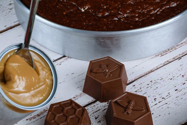 Small chocolate molds for making Brazilian honey cake, next to a can of dulce de leche.