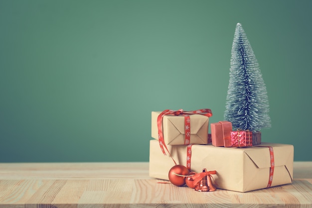 small Christmas tree and boxes with gifts on a wooden table