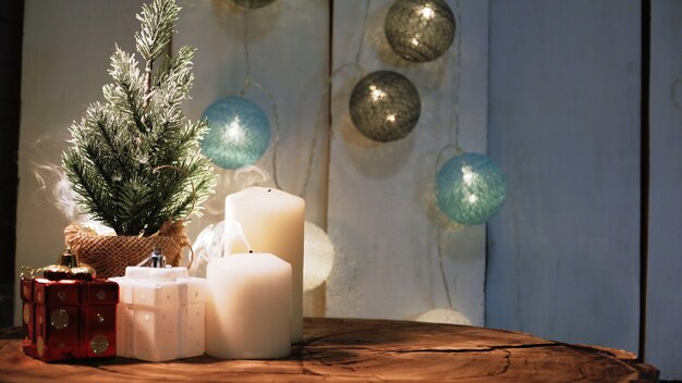 Small Christmas tree and candles on a wooden surface