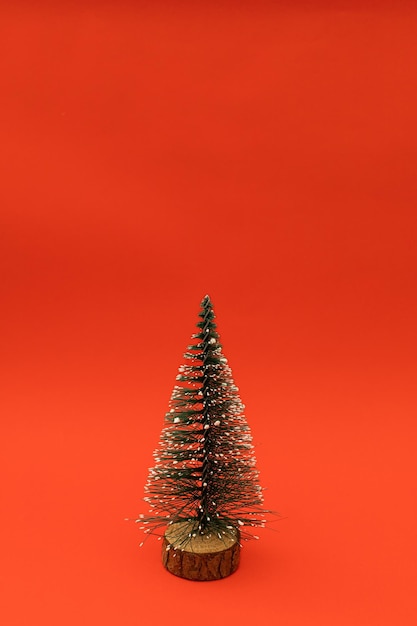 A small Christmas tree on a red holiday background