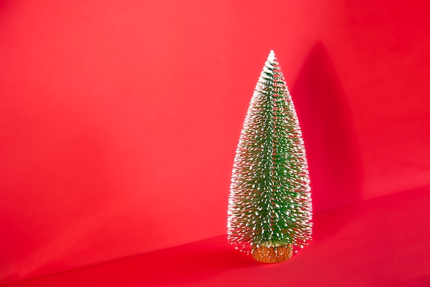 Photo small christmas tree on red