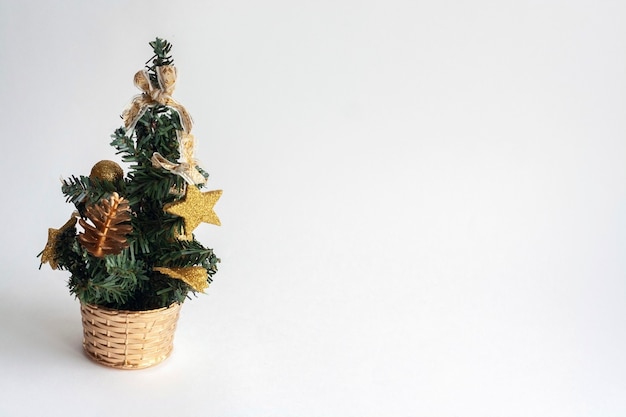 Small Christmas tree with toys in a basket, isolated, copy space