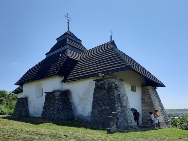 A small church with a black roof and a small tower with a steeple.