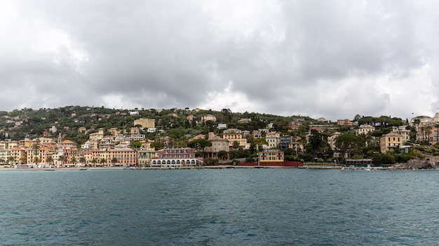 Piccola città vicino a portofino dal mare con un cielo drammatico