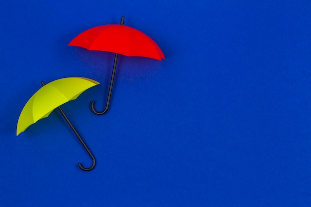 Small colorful umbrellas on blue color