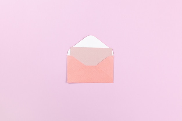 Small coral envelope with empty card inside on lilac background