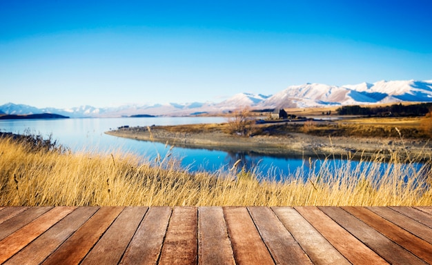 Small cottage in a rural area with a view of mountains and lake.