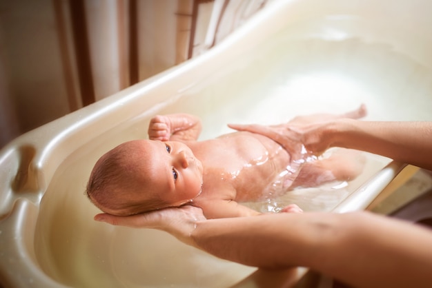 Small cute big-eyed beautiful baby bathes