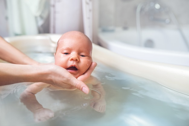 Small cute big-eyed beautiful baby bathes