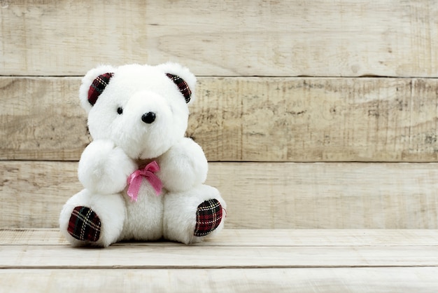 Small cute teddy bear on wooden background