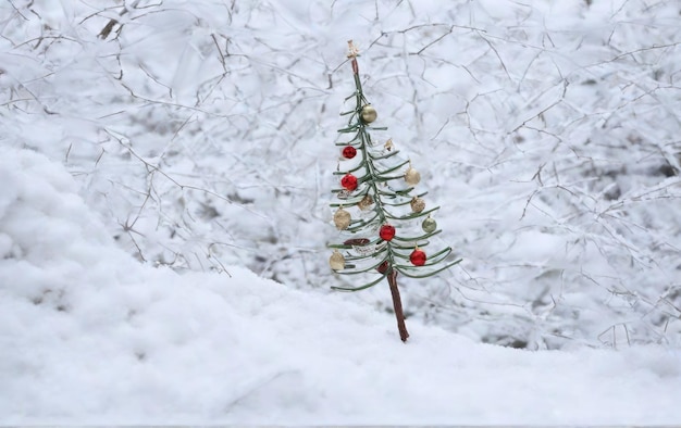 雪の中に閉じ込められた小さな装飾的なクリスマスツリー