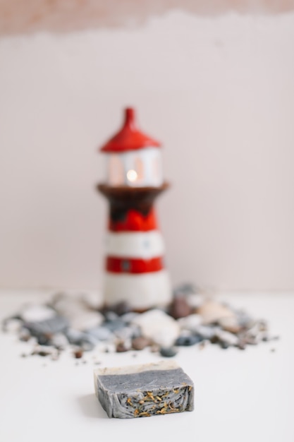 A small decorative lighthouse with sea shells and pebbles.