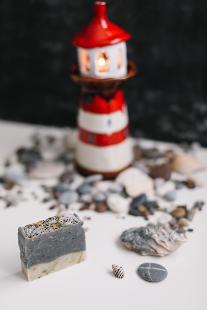 貝殻と小石のある小さな装飾的な灯台。