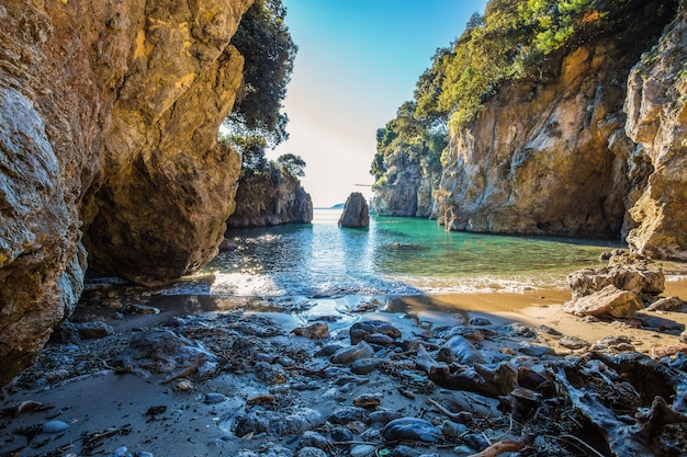Foto la piccola spiaggia deserta situata tra le rocce con bella acqua verde e chiara