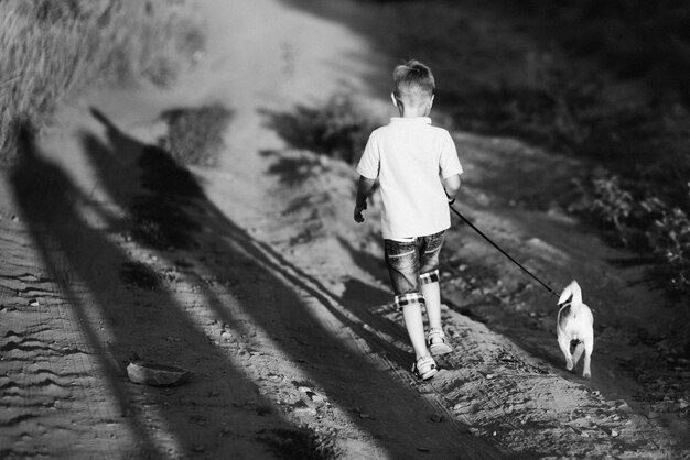 A small dog of the Jack Russell Terrier breed on a walk with its owners