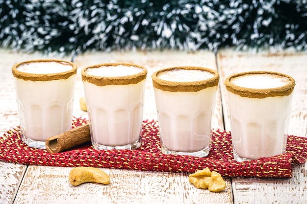 Photo small doses of eggnog or alcoholic eggnog is an alcoholic beverage, an american cocktail, served in the christmas dinner