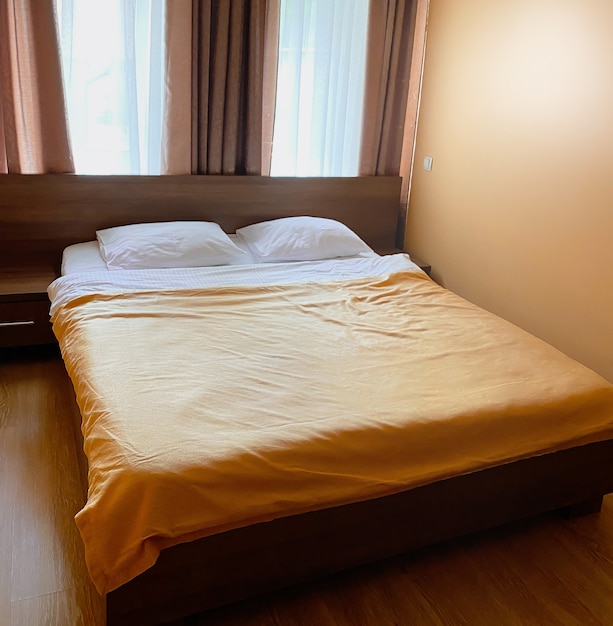 Small double room in the hotel with a small area in beige colors with a double bed.