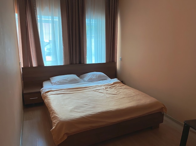 Small double room in the hotel with a small area in beige colors with a double bed