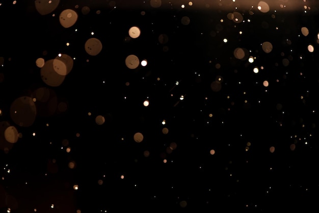 Foto piccole gocce di pioggia neve su uno sfondo nero vento sfondo naturale dorato