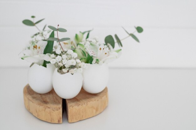 A small egg holder with white flowers sits on a table