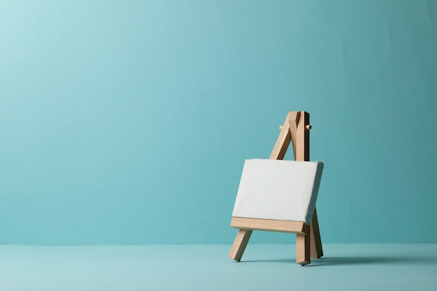 Small empty easel for drawing on a blue background