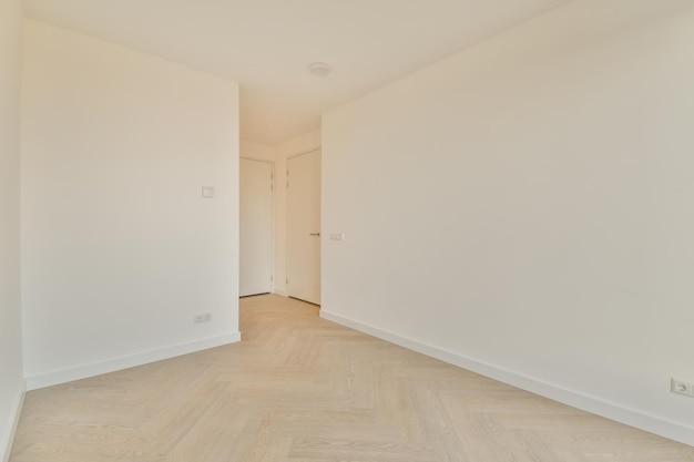 A small empty room in white tones with a parquet floor in a modern apartment