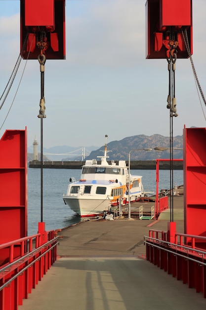 Photo small ferry at port on sea against sky and mountain