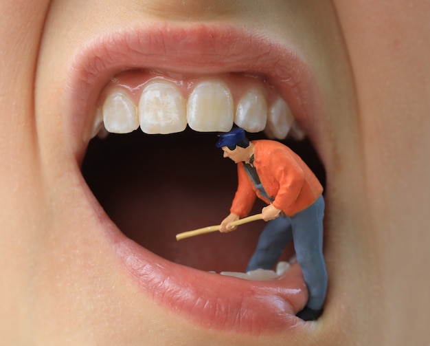 Small figure worker cleaning tooth model