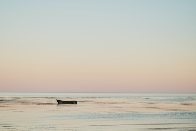 夕暮れの夕日の湾で小型漁船