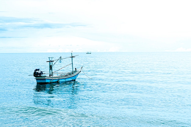 青い空と青い海に浮かぶ小さな漁船、タイの漁船または漁船またはサムロイヨッドビーチの船プラチュワップキーリーカーンタイの青い空と雲と青い海