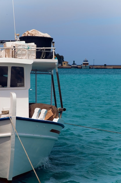 A small fishing boat tied into harbour on a beautiful sea 