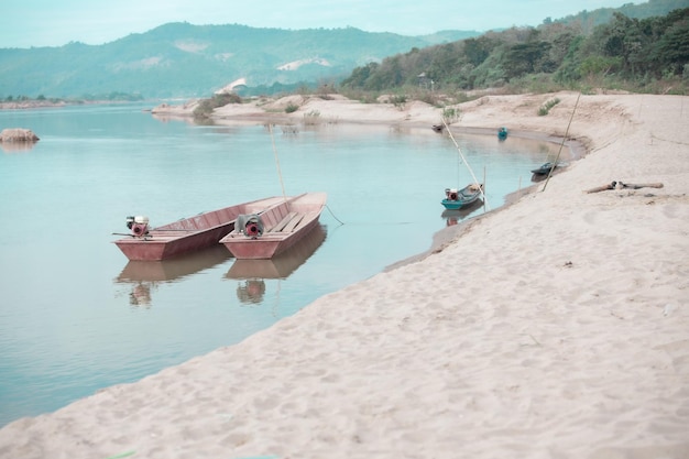 Small fishing boat with fishing net and equipment A longtailed boat stranded on the beach for repairs at HuayLa Beach