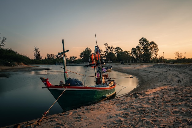 Small fishing boats are moored along the sea shore