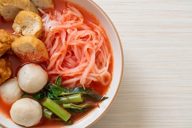 Piccole tagliatelle di riso con polpette di pesce e polpette di gamberi in zuppa rosa yen ta four o yen ta fo