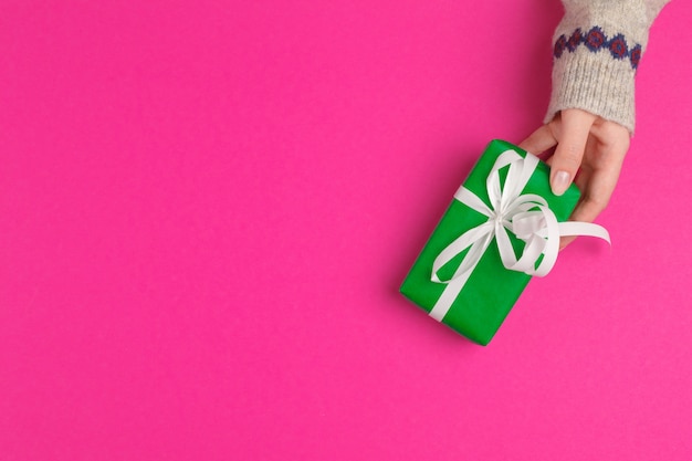 Small gift box in female hands, view from above