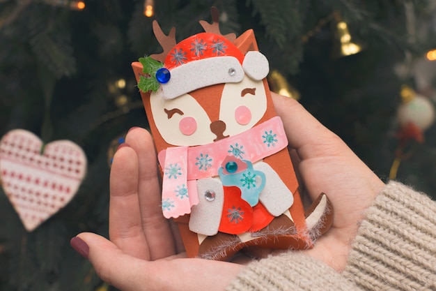 Small gift deer in the hands. Holiday concept.