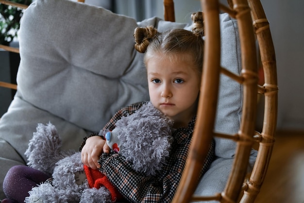 A small girl in a bamboo chair