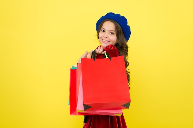 Small girl child with shopping bags Birthday and christmas presents International childrens day big sale in shopping mall Happy shopping online Pleasant shopping Choosing the best