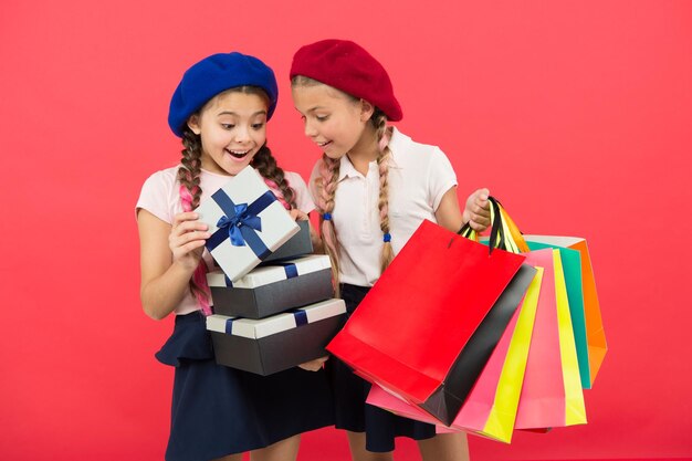 ショッピングバッグの友情と姉妹関係を持つ小さな女の子の子供たち誕生日とクリスマスのプレゼントショッピングモールでの国際的な子供の日大セールハッピーショッピングオンラインショッピング成功