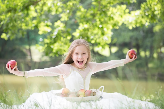 Маленькая девочка в платье с корзиной с фруктами