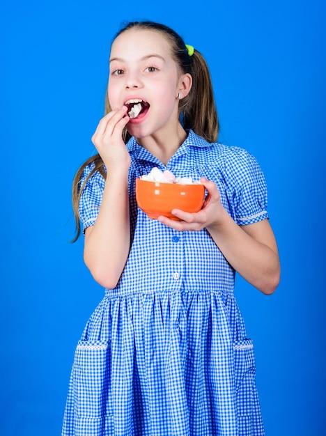 Small girl eat marshmallow dieting and calorie sweet tooth\
concept happy little child love sweets and treats healthy food and\
dental care marshmallow candy shop healthy food is healthy\
life