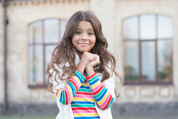 Small girl gorgeous hairstyle adorable smile urban background, so cute concept.