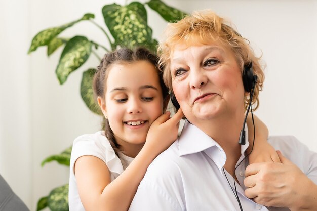 Foto una bambina e una nonna in cuffia a casa.