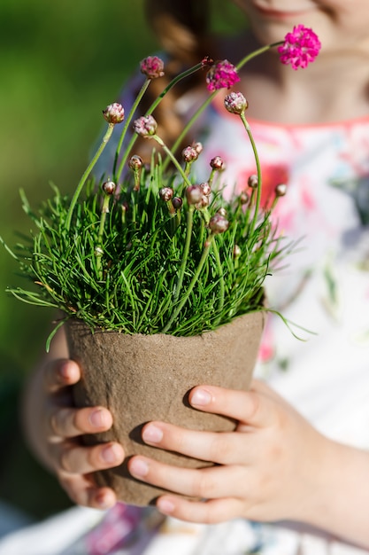 Small girl holding a flower pot