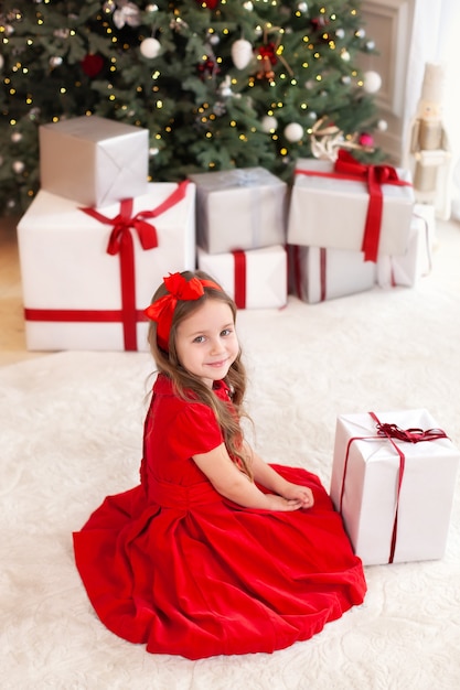 작은 소녀는 크리스마스 선물을 엽니 다.
